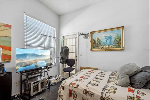 a bedroom with a bed and a flat screen tv