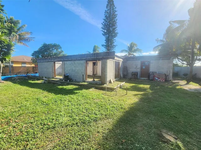 a view of a house with a big yard and potted plants