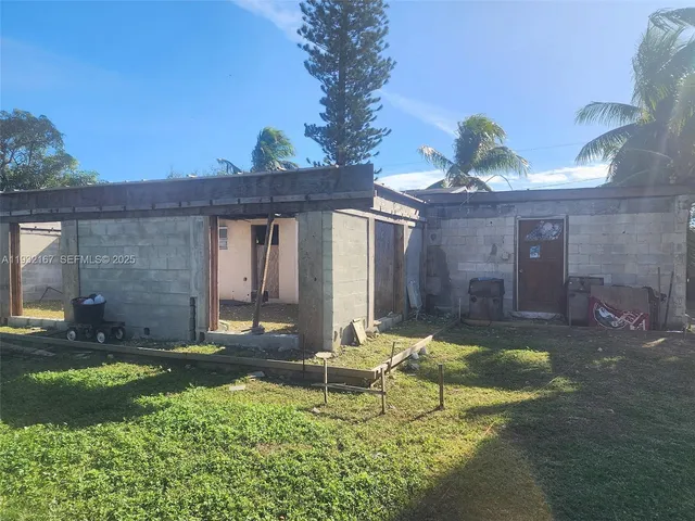 a house view with a sitting space fire pit and outdoor space
