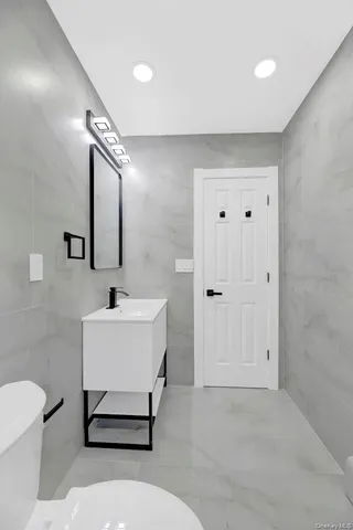 a bathroom with a white sink vanity and a mirror