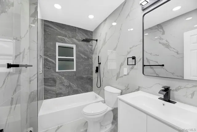 a bathroom with a sink toilet vanity and shower