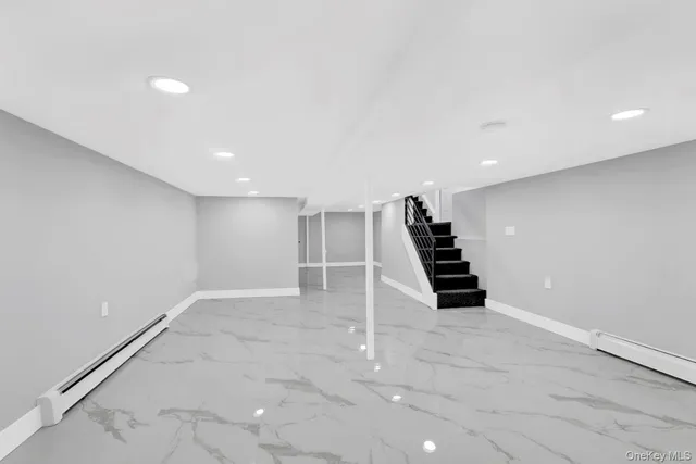 an empty room with wooden floor and staircase