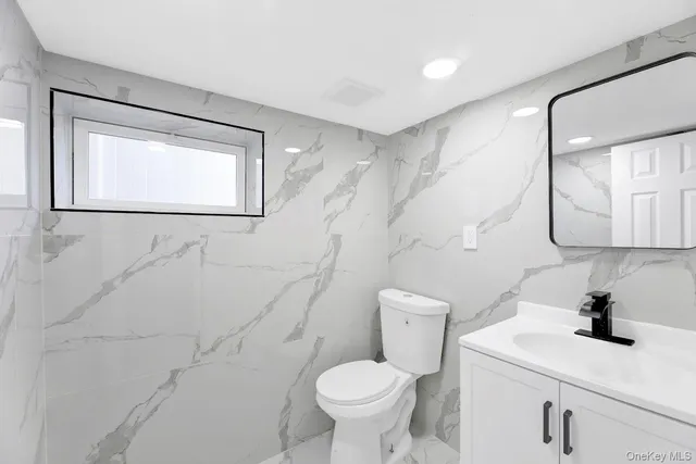 a bathroom with a toilet sink and mirror