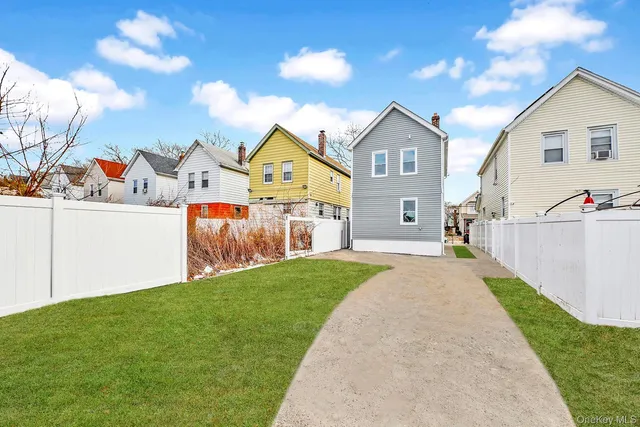 a view of a house with a yard and large trees