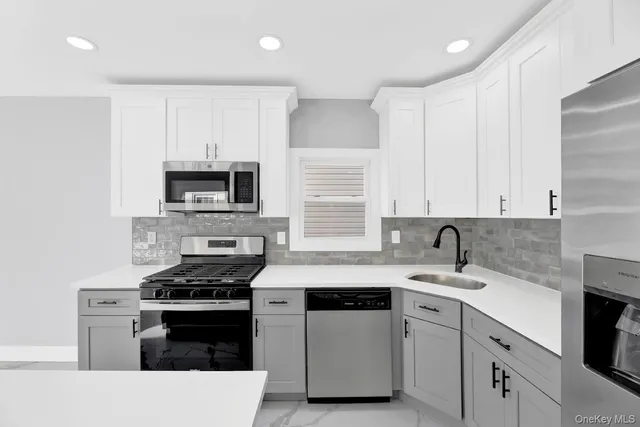 a kitchen with cabinets appliances a sink and a counter top space