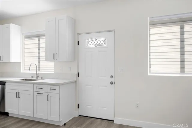 a kitchen with white cabinets and sink