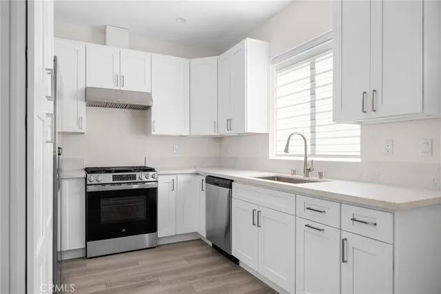 a kitchen with cabinets appliances a sink and a window