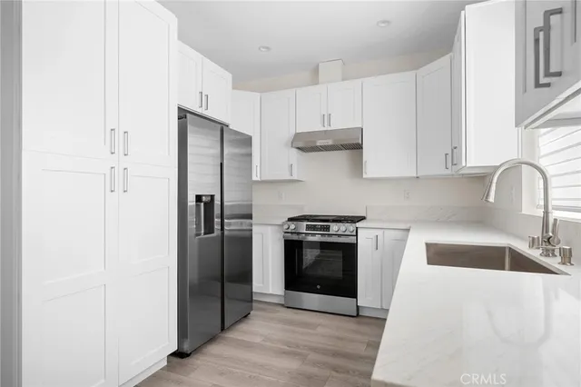 a kitchen with stainless steel appliances granite countertop a refrigerator stove and sink