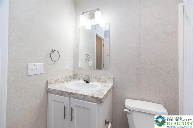 a bathroom with a toilet sink and mirror