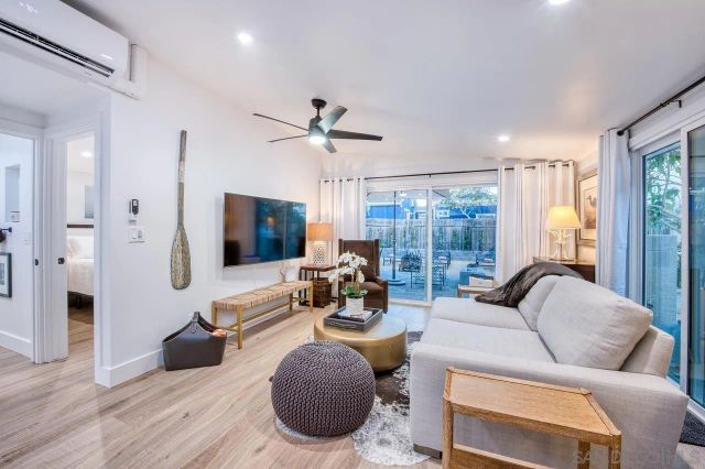 a living room with furniture wooden floor and a large window