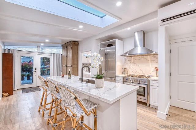 a kitchen with stainless steel appliances granite countertop a table chairs and a refrigerator