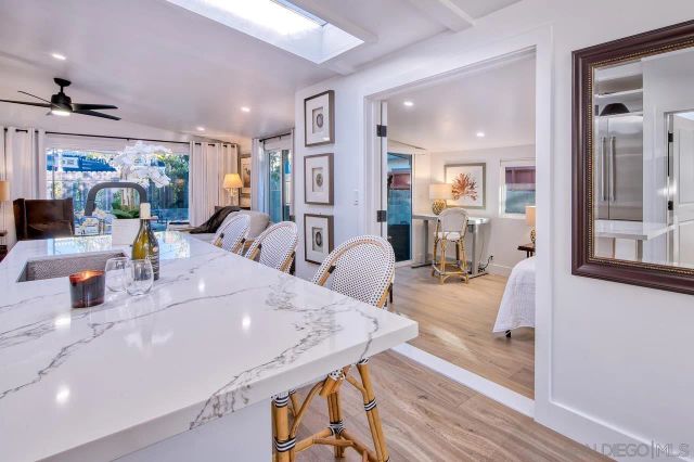 a dining hall with stainless steel appliances furniture a large window and a wooden floor