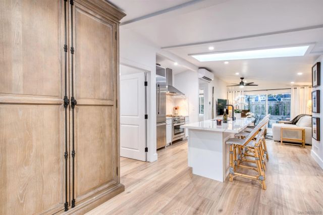 a living room with stainless steel appliances furniture and a wooden floor