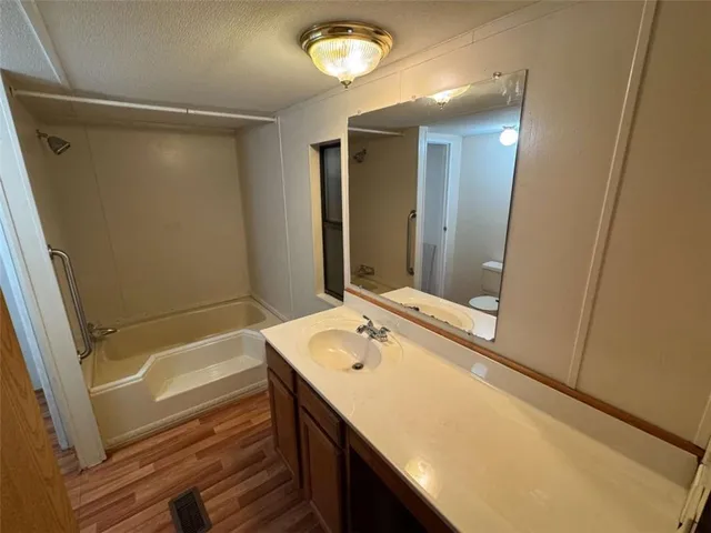 a bathroom with a sink a tub and a mirror