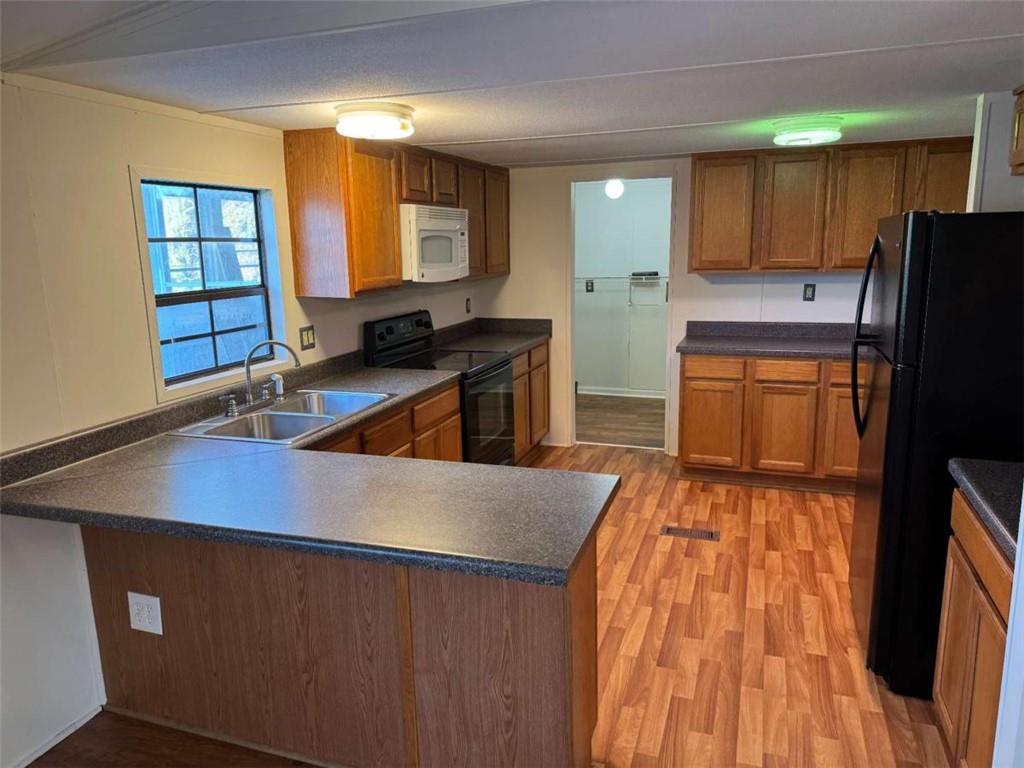 4044 Friendship Road Buford, GA 30519 - Photo 8 of 30 a kitchen with wooden cabinets a sink a stove and a refrigerator