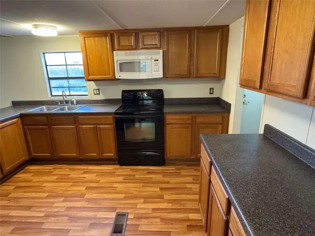 a kitchen with stainless steel appliances granite countertop a stove a sink and a microwave