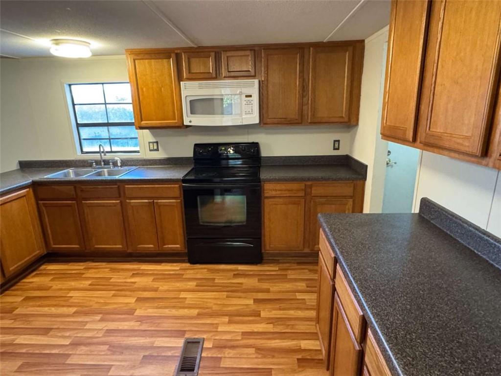 4044 Friendship Road Buford, GA 30519 - Photo 9 of 30 a kitchen with stainless steel appliances granite countertop a stove a sink and a microwave