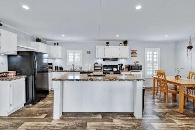 104 Private Road 1114 Decatur, TX 76234 - Photo 8 of 39 a kitchen with stainless steel appliances granite countertop a stove top oven a sink a refrigerator white cabinets and wooden floor