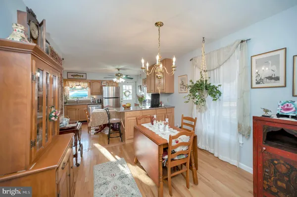 a view of a dining room and livingroom with furniture wooden floor a chandelier