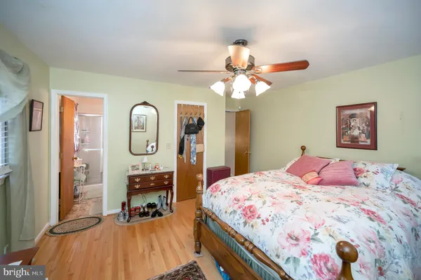 a bedroom with a bed a chandelier and dresser