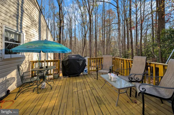 a view of deck with table and chairs under an umbrella with wooden floor