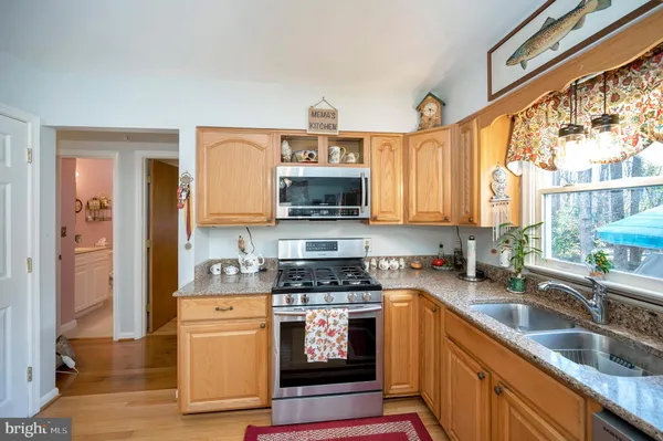 a kitchen with granite countertop a stove a sink and a refrigerator