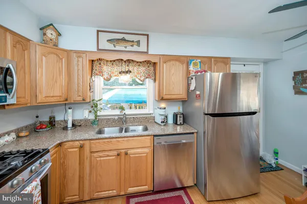 a kitchen with stainless steel appliances a refrigerator sink and cabinets