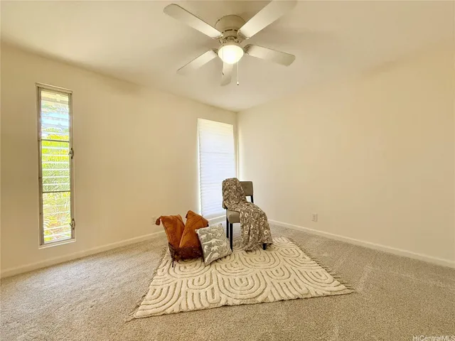 a bed sitting in a bedroom next to a window and a chandelier