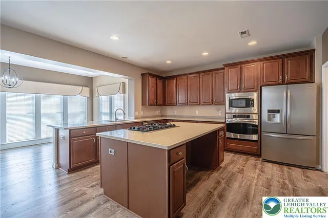 a kitchen with stainless steel appliances granite countertop a refrigerator and a sink