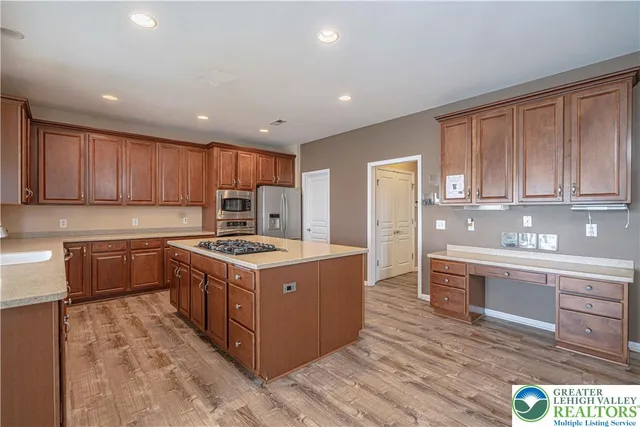 a kitchen with stainless steel appliances granite countertop wooden cabinets and a stove top oven