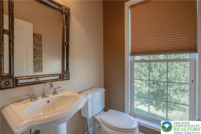a bathroom with a tub a double vanity sink and a large mirror