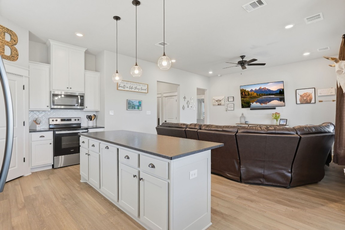 173 Brazos Bend Snook, TX 77879 - Photo 15 of 41 a kitchen with stainless steel appliances granite countertop a sink a stove a refrigerator and island with wooden floor