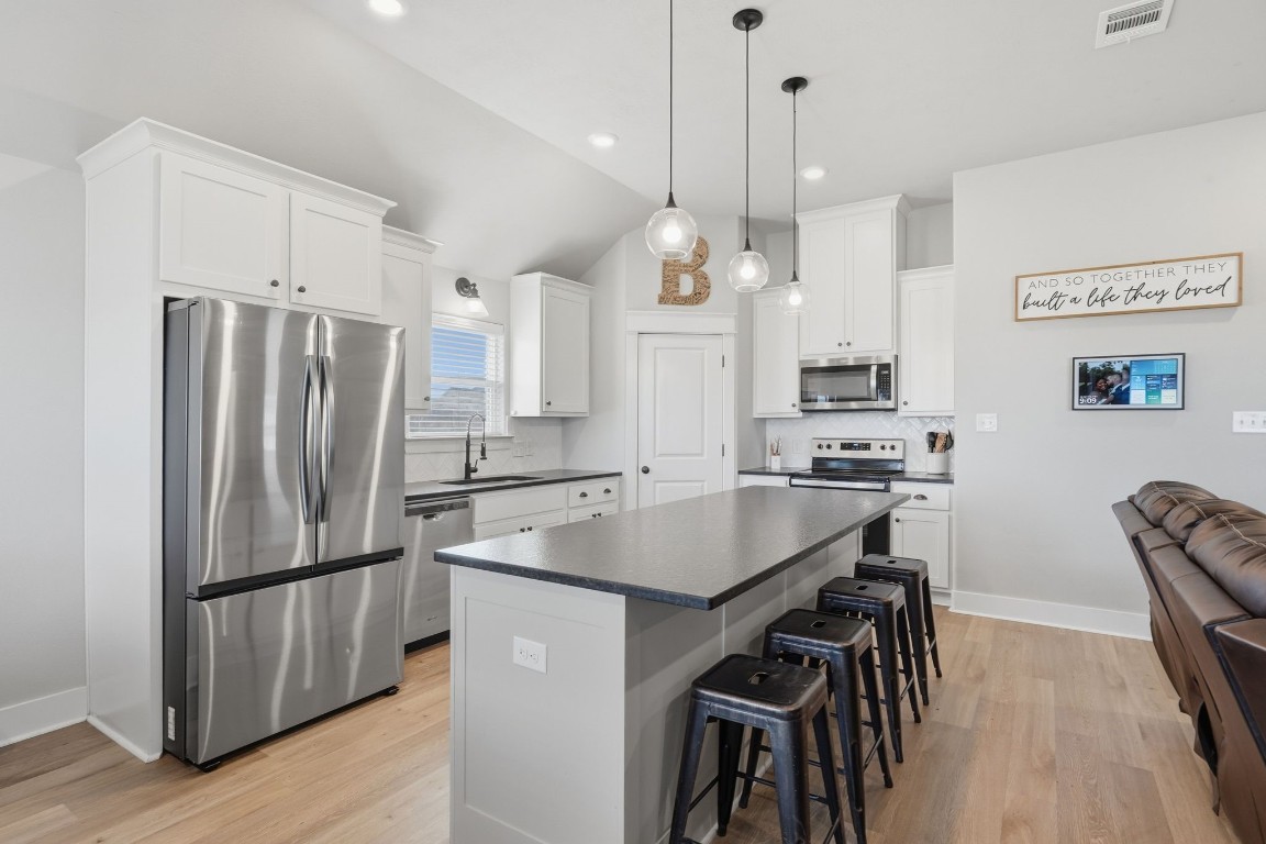 173 Brazos Bend Snook, TX 77879 - Photo 16 of 41 a kitchen with kitchen island a refrigerator a stove a sink and a chairs
