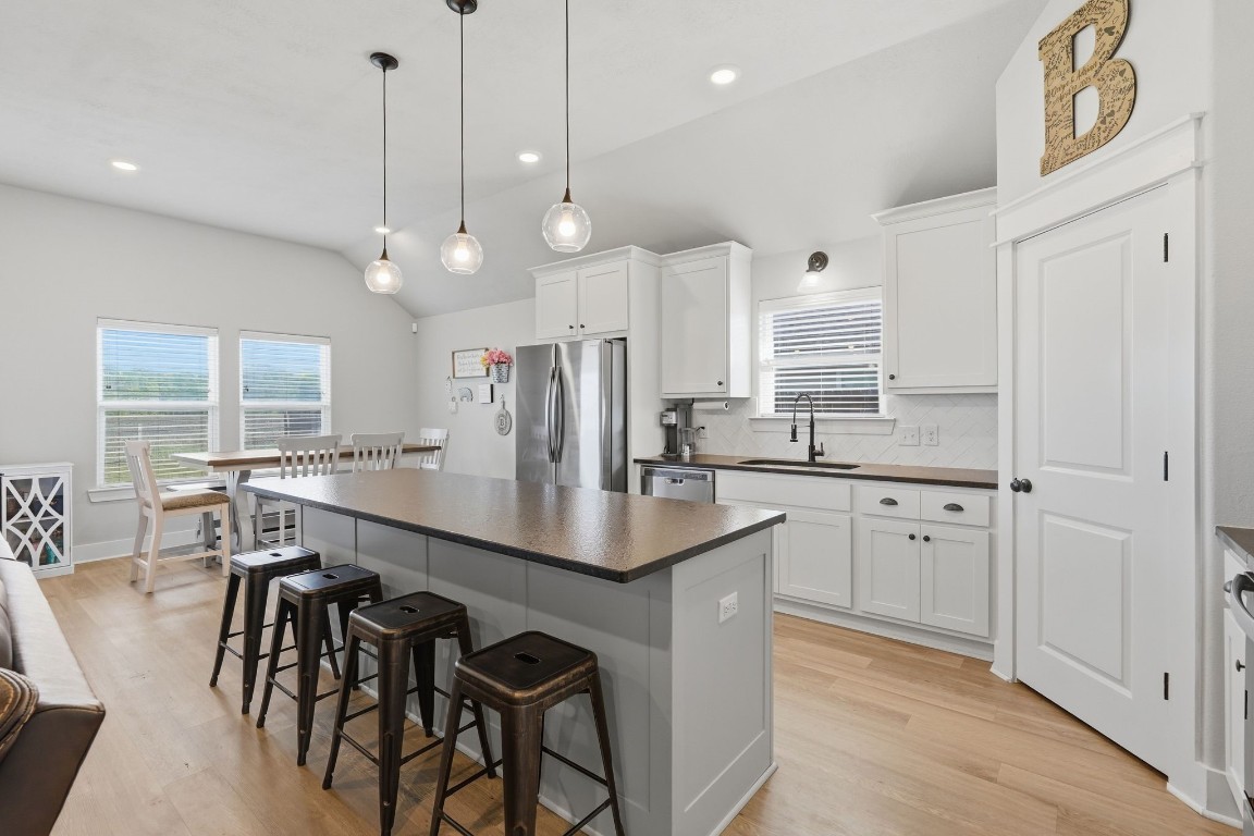 173 Brazos Bend Snook, TX 77879 - Photo 18 of 41 an open kitchen with granite countertop a stove a sink a center island a refrigerator and a wooden floor