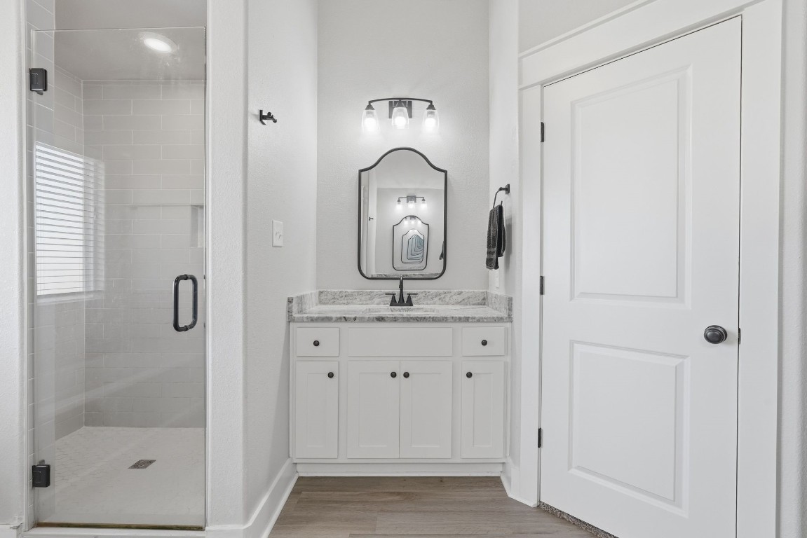 173 Brazos Bend Snook, TX 77879 - Photo 25 of 41 a bathroom with a granite countertop sink a mirror and shower