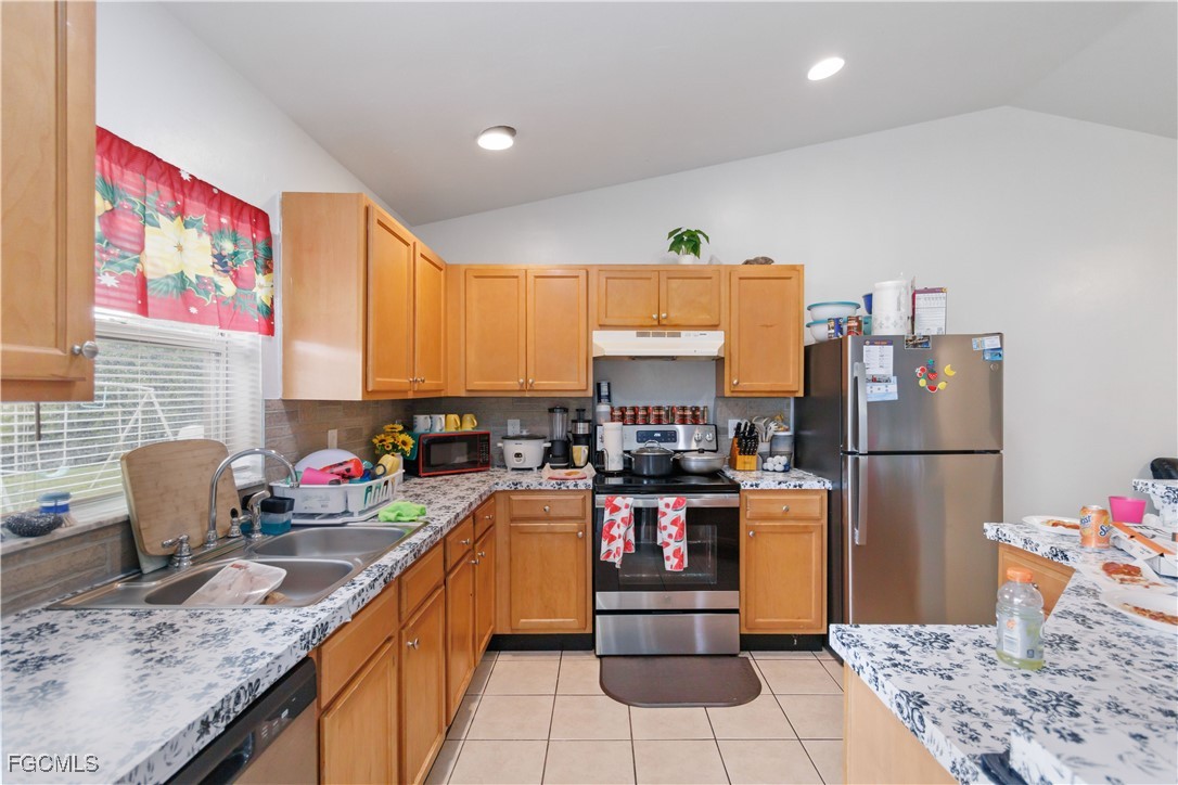 776-778 Alabama Road South Lehigh Acres, FL 33974 - Photo 15 of 50 a kitchen with stainless steel appliances granite countertop a refrigerator sink and stove