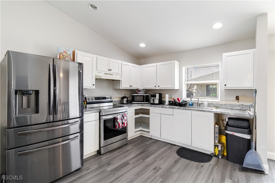 776-778 Alabama Road South Lehigh Acres, FL 33974 - Photo 17 of 50 a kitchen with a refrigerator cabinets and wooden floor