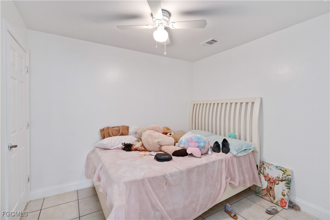776-778 Alabama Road South Lehigh Acres, FL 33974 - Photo 21 of 50 a bed sitting in a bedroom next to a window and a chandelier