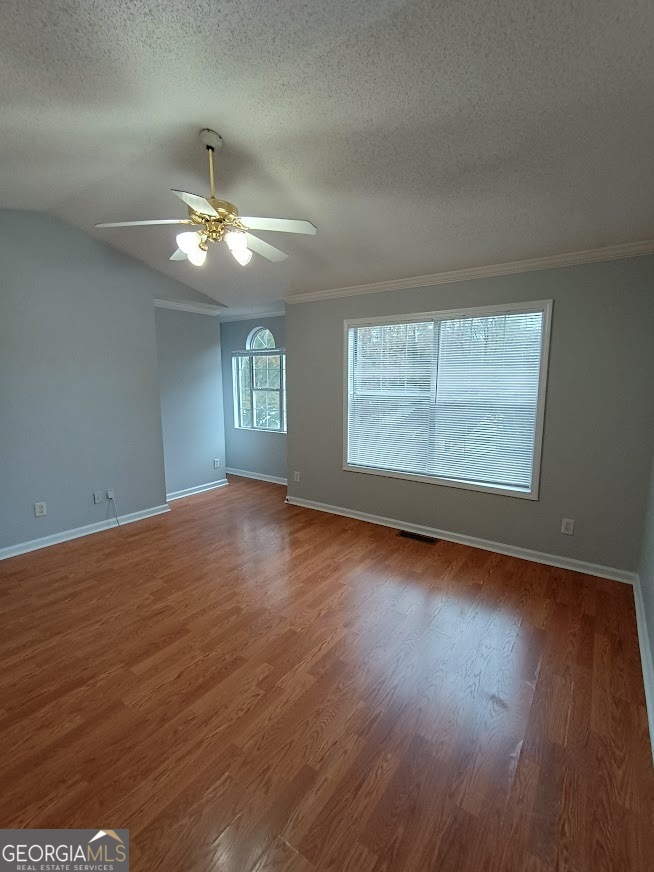 7355 Drake Avenue Lithonia, GA 30058 - Photo 13 of 20 an empty room with wooden floor chandelier fan and windows