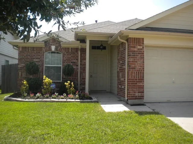 a front view of a house with a garden and plants