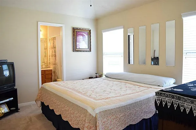 a bedroom with a bed dresser and a window