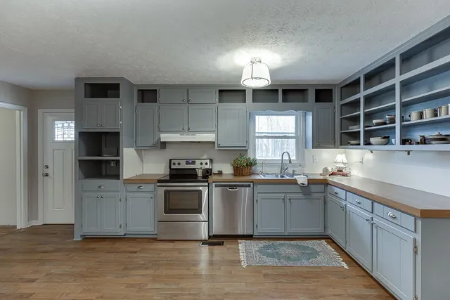 a kitchen with stainless steel appliances granite countertop a sink and cabinets