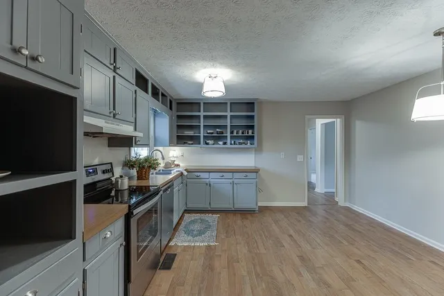 a kitchen with granite countertop a stove and a refrigerator