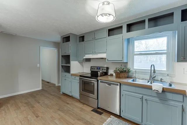 a kitchen with stainless steel appliances a sink stove and cabinets