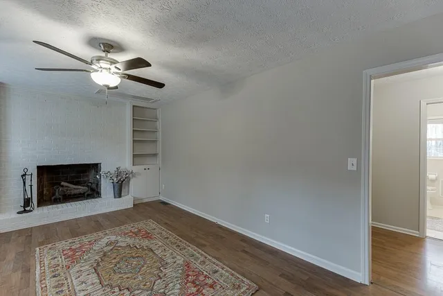 a view of empty room with wooden floor and fireplace
