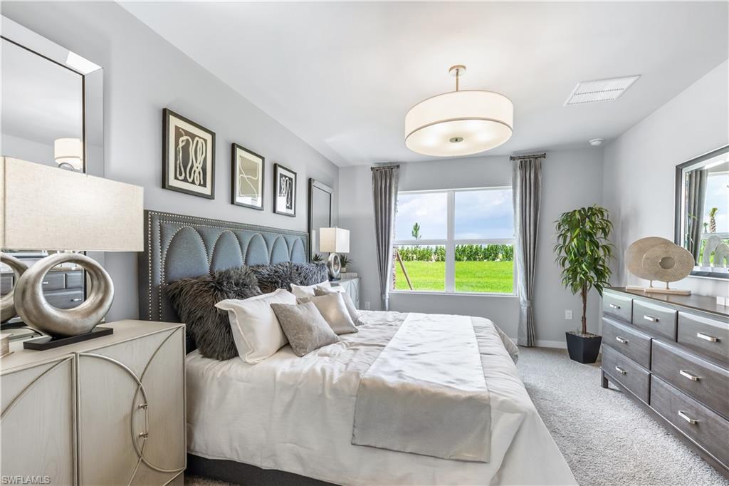 17767 Shade Tree Loop Punta Gorda, FL 33982 - Photo 8 of 35 a bedroom with a bed and a chandelier