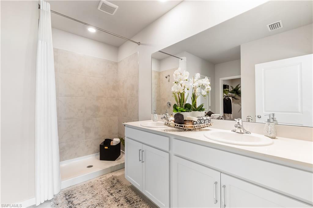 17767 Shade Tree Loop Punta Gorda, FL 33982 - Photo 9 of 35 a bathroom with a sink double vanity granite tub shower and a mirror
