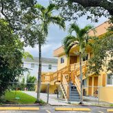 a view of a tall building next to a road with an trees