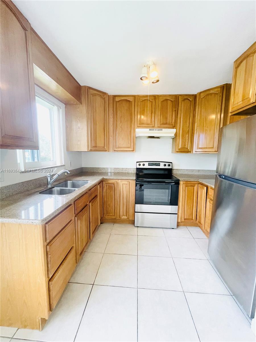 5261 Southwest 90th Way, Unit 3 Cooper City, FL 33328 - Photo 2 of 7 a kitchen with stainless steel appliances granite countertop a sink and cabinets