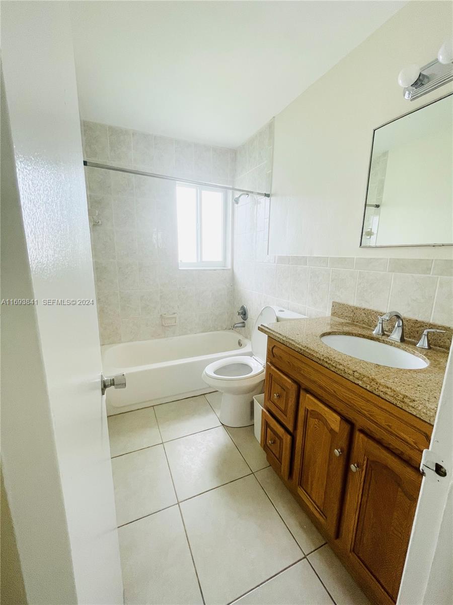 5261 Southwest 90th Way, Unit 3 Cooper City, FL 33328 - Photo 4 of 7 a bathroom with a granite countertop sink toilet and shower